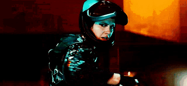 a woman wearing a motorcycle helmet and goggles is holding a remote control .
