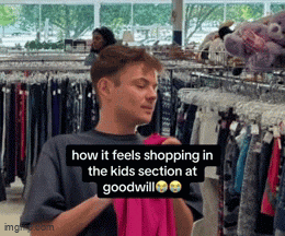 a man is holding a pink shirt in a store with a caption that reads how it feels shopping in the kids section at goodwill