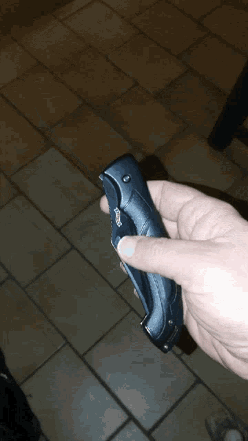 a person is holding a knife that has a button on it that says ' unlock '