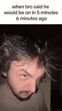 a man with a beard and messy hair looks at the camera with the caption when bro said he would be on in 5 minutes