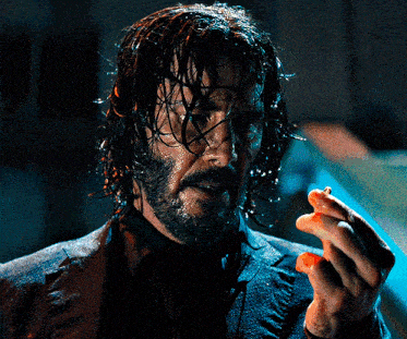 a man with wet hair and a beard is holding something in his hand