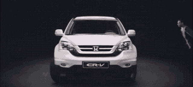 a white honda cr-v with two men jumping on it