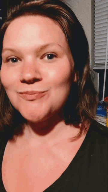 a woman with a nose ring looks at the camera and smiles