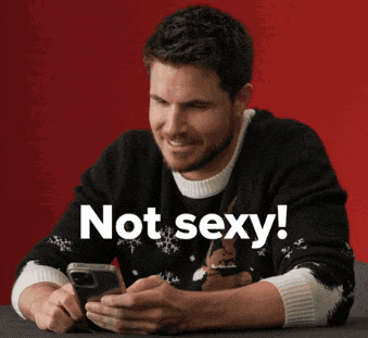 a man wearing an ugly christmas sweater is looking at his phone with the words not sexy behind him