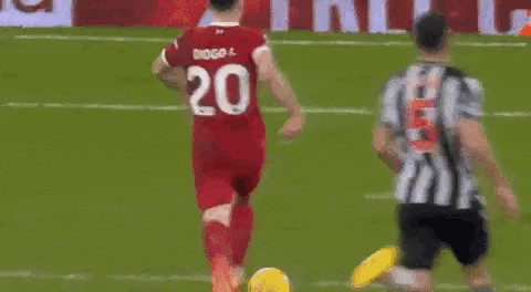 two soccer players are playing a game of soccer on a field with a sign in the background .
