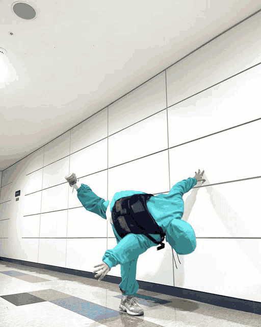 a person in a blue outfit is doing a handstand