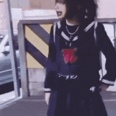 a girl in a school uniform is standing in front of a building and a car .