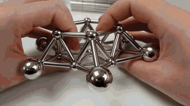 a person is playing with a magnetic toy that looks like a pyramid
