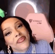 a woman is making a funny face while sitting in a pink chair .