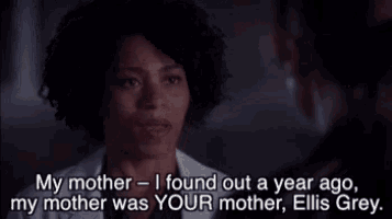 a woman in a white coat is talking to a man in a dark room .
