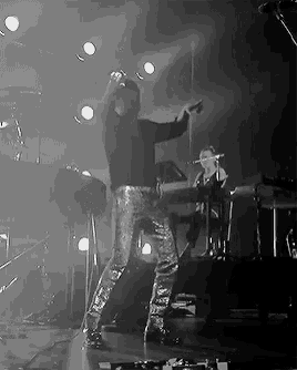 a black and white photo of a man dancing on stage