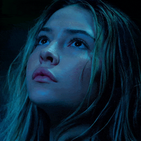 a close up of a woman 's face in a dark room