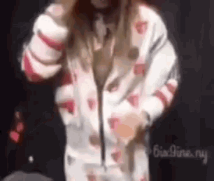 a woman is wearing a white jacket with hearts on it .