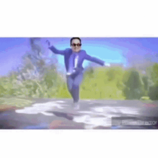 a man in a suit and tie is jumping over a puddle of water .