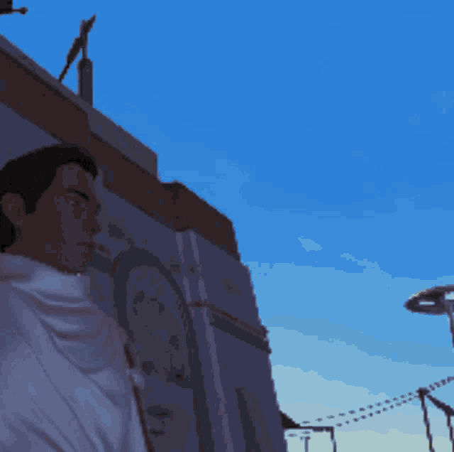 a man standing in front of a building with a blue sky behind him