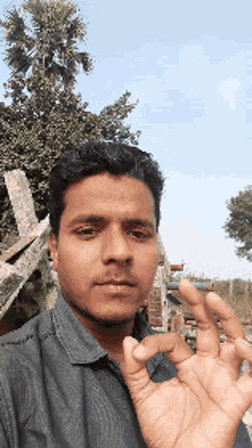 a man in a black shirt is giving the ok sign with his hand