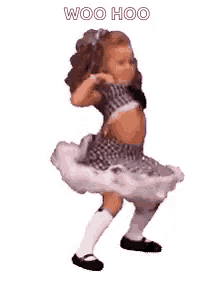 a little girl is dancing in a tutu and a crop top .
