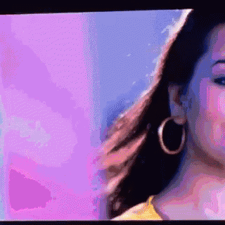 a close up of a woman 's face wearing hoop earrings on a television screen .