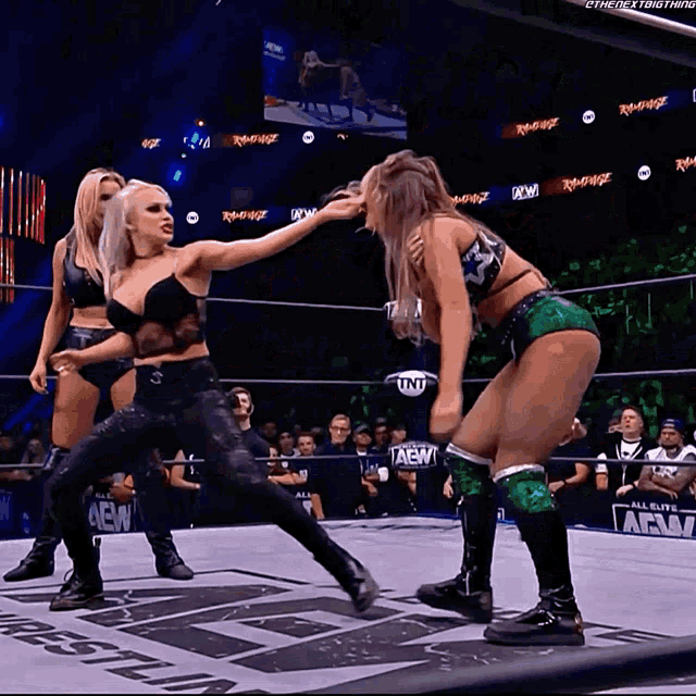two women in a wrestling ring with the word aew on the wall