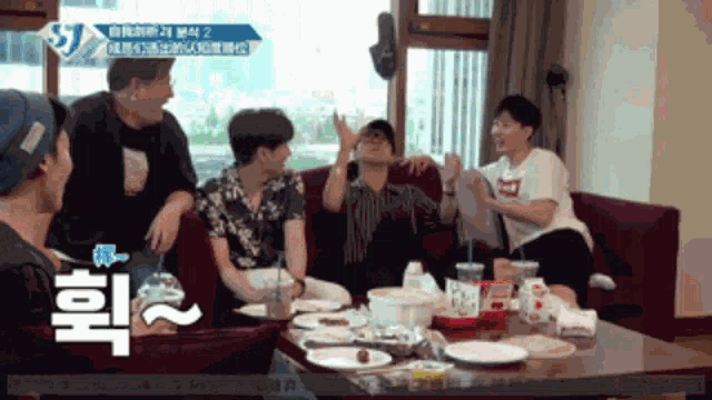a group of people are sitting around a table with plates and cups and a sign that says st.