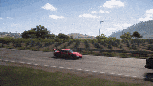 a red sports car is driving down a road in a video game