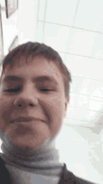 a close up of a young boy 's face with his eyes closed .