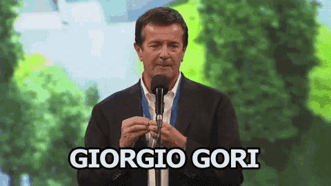 a man speaking into a microphone with the name giorgio gori written on the bottom
