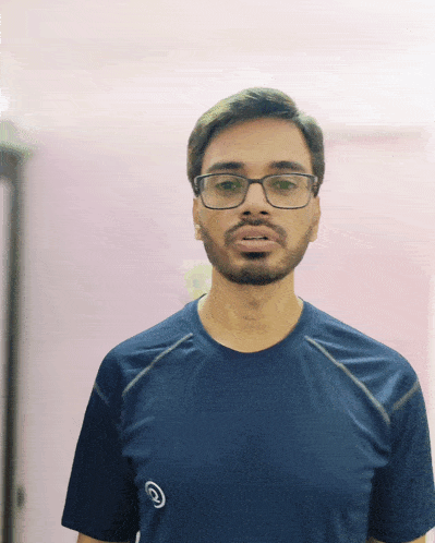 a man with glasses and a beard wears a blue shirt with the letters g on it