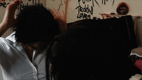 a woman screams in front of a wall that says teddy loves