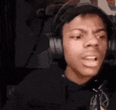 a young man is wearing headphones and making a funny face .