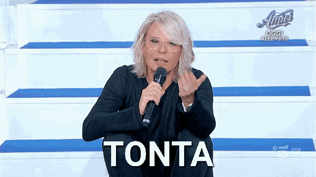a woman sitting on a staircase holding a microphone with the word tonta above her