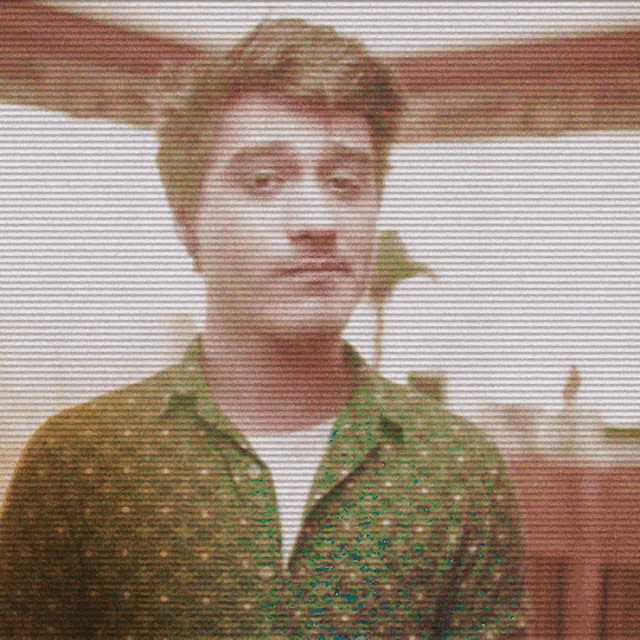 a blurry picture of a man with a green shirt