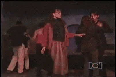 a woman in a long skirt is dancing on a dance floor with other people .