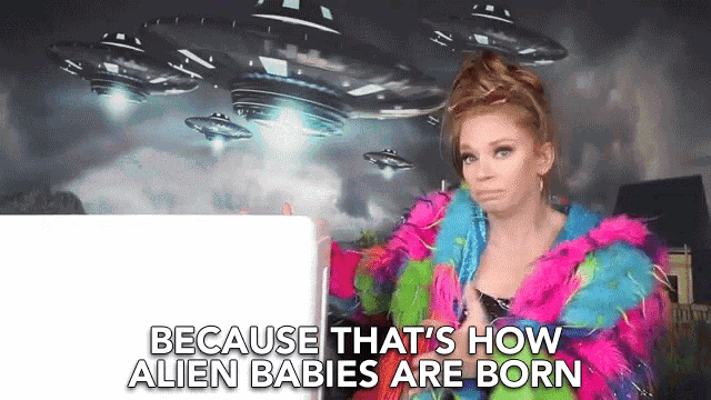 a woman in a colorful coat is talking about how alien babies are born