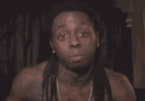 a man with dreadlocks is making a funny face while wearing a necklace .