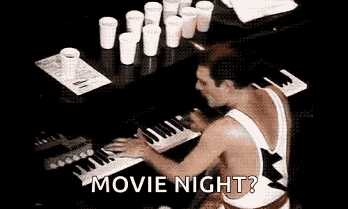 a man is playing a piano in front of a table with cups on it .