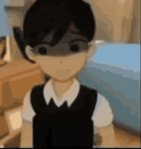 a blurry picture of a boy in a black vest and white shirt .