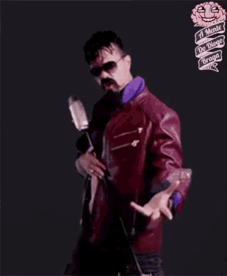 a man singing into a microphone without a shirt on .