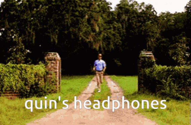 a man walking down a dirt road with the words quin 's headphones on the bottom right