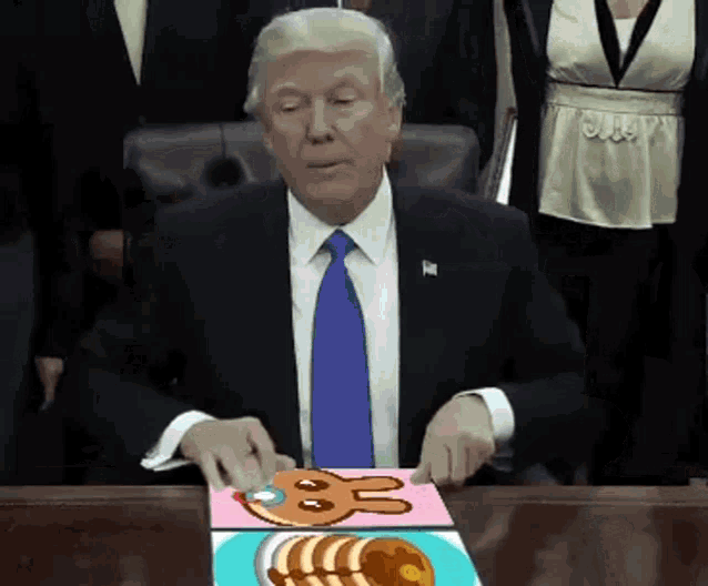 a man in a suit and tie is sitting at a table with a plate of food on it