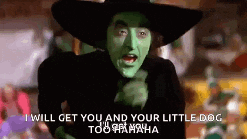 the witch from the wizard of oz is wearing a green hat and pointing .