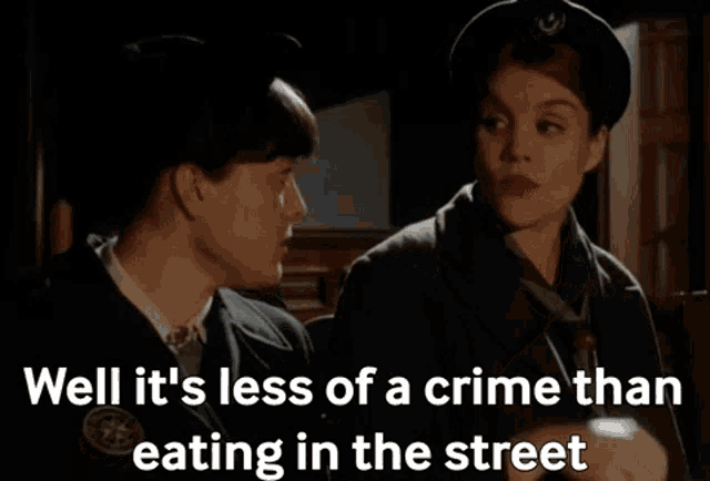 a man and a woman are talking with the words well it 's less of a crime than eating in the street below them