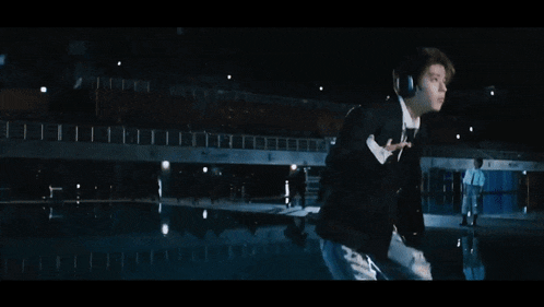 a man in a suit and tie is jumping into a pool