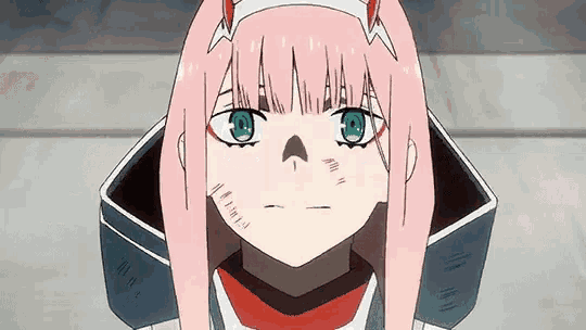 a girl with pink hair and green eyes is looking at the camera with a scar on her face .