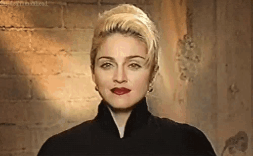 a close up of a woman wearing a black coat and red lipstick .