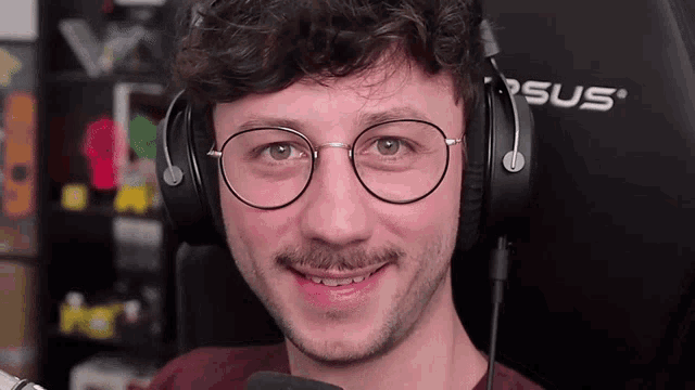 a man wearing glasses and headphones is smiling for the camera