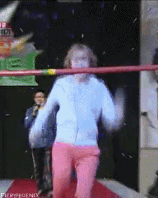 a woman in a white jacket and pink pants is dancing in a ring with fieryphoenix written on the bottom right