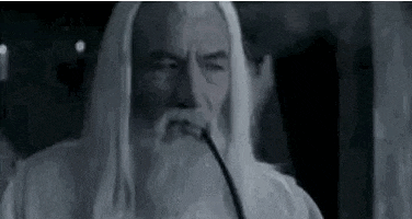 a man with long white hair and a beard is smoking a pipe in a black and white photo .