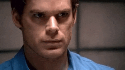 a close up of a man 's face in a blue shirt looking at the camera .