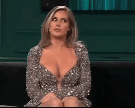 a woman in a silver sequined dress is sitting on a couch .